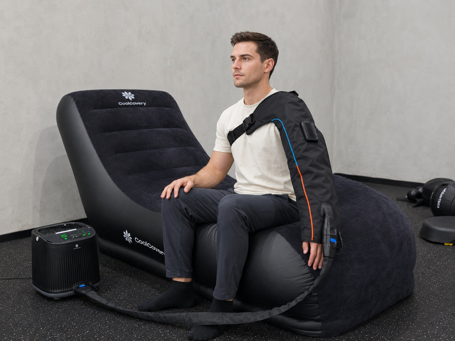 Man sit  on a compression sofa using coolcovery sleeve to recover his arm
